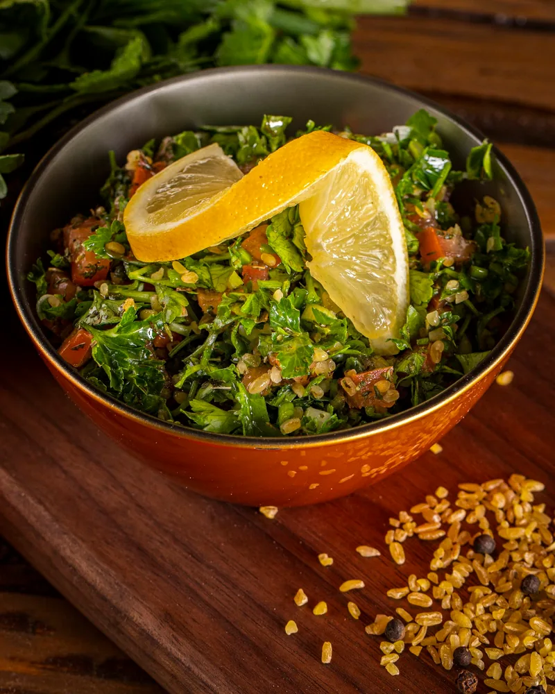 Tabbouleh salad in a bowl garnished with a lemon slice at 1001 Nights
