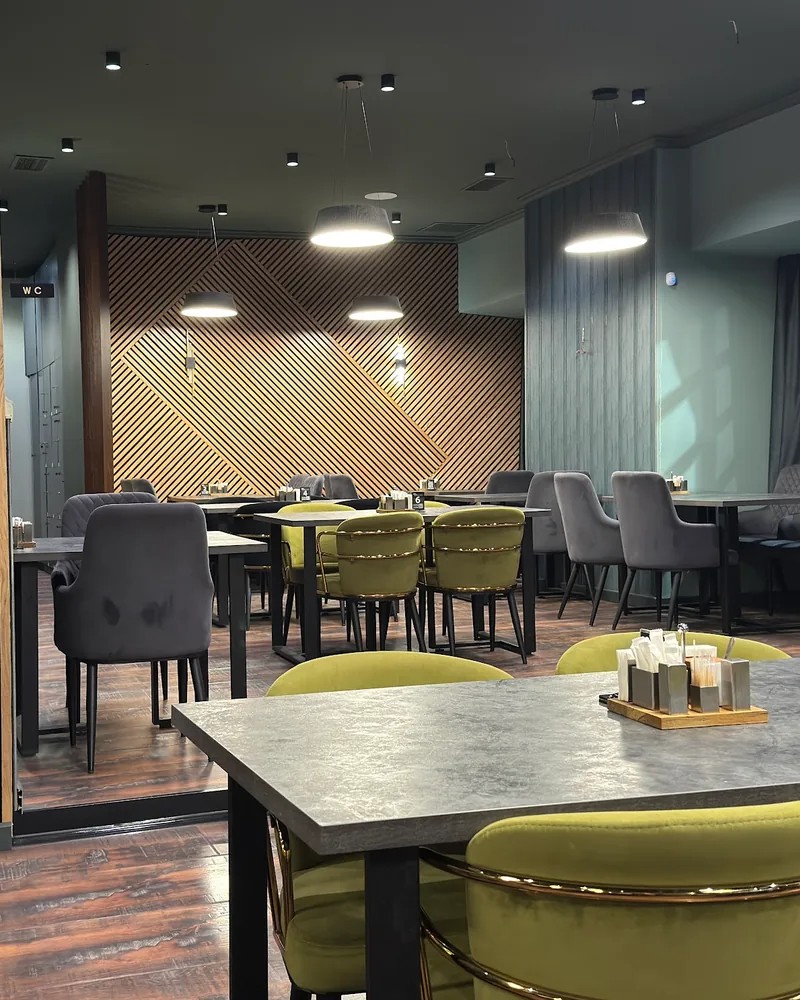 Dining area with modern chairs and wood slatted accents at 1001 Nights