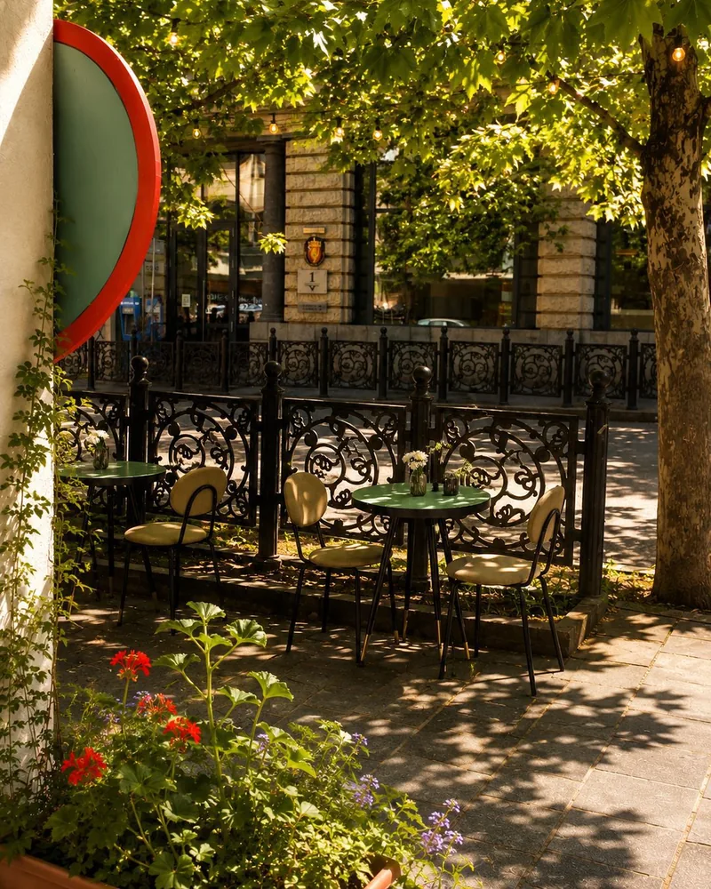 Outdoor sidewalk cafe seating under tree shade at 11:11 Cafe-Bar & Restaurant