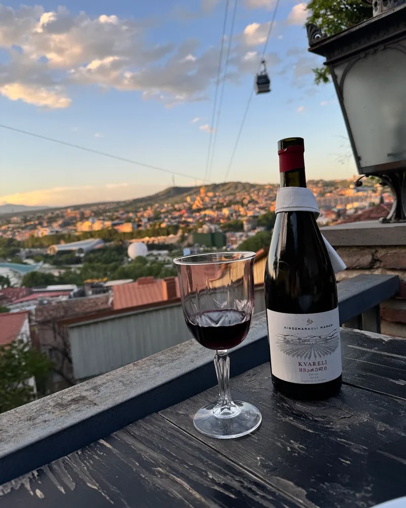Red wine in a stemmed glass and wine bottle at 144 Stairs
