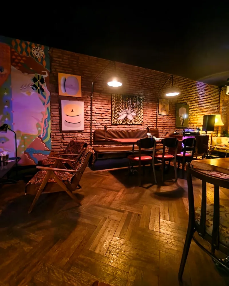 Brick-walled seating area with retro armchairs and warm lamps at 5327°