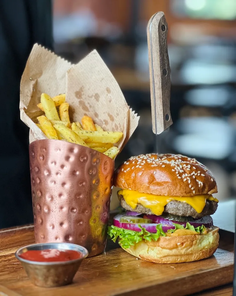 Cheeseburger and fries served with ketchup on a wooden board at #8 BBQ House