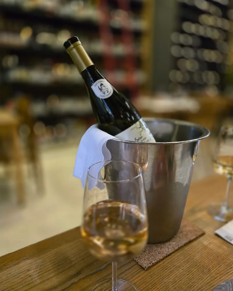 White wine bottle in an ice bucket with a glass in the foreground at 8000 Vintages (Vake)