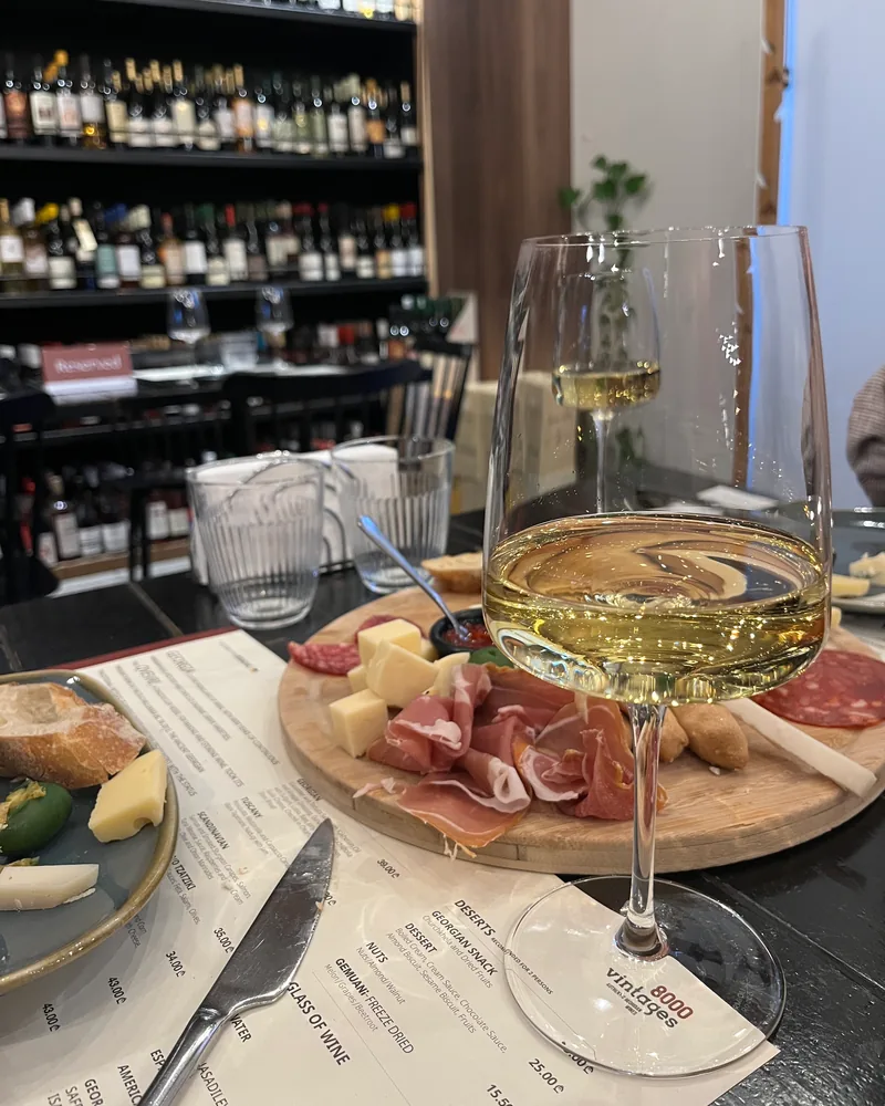 White wine in a wine glass with charcuterie board at 8000 Vintages