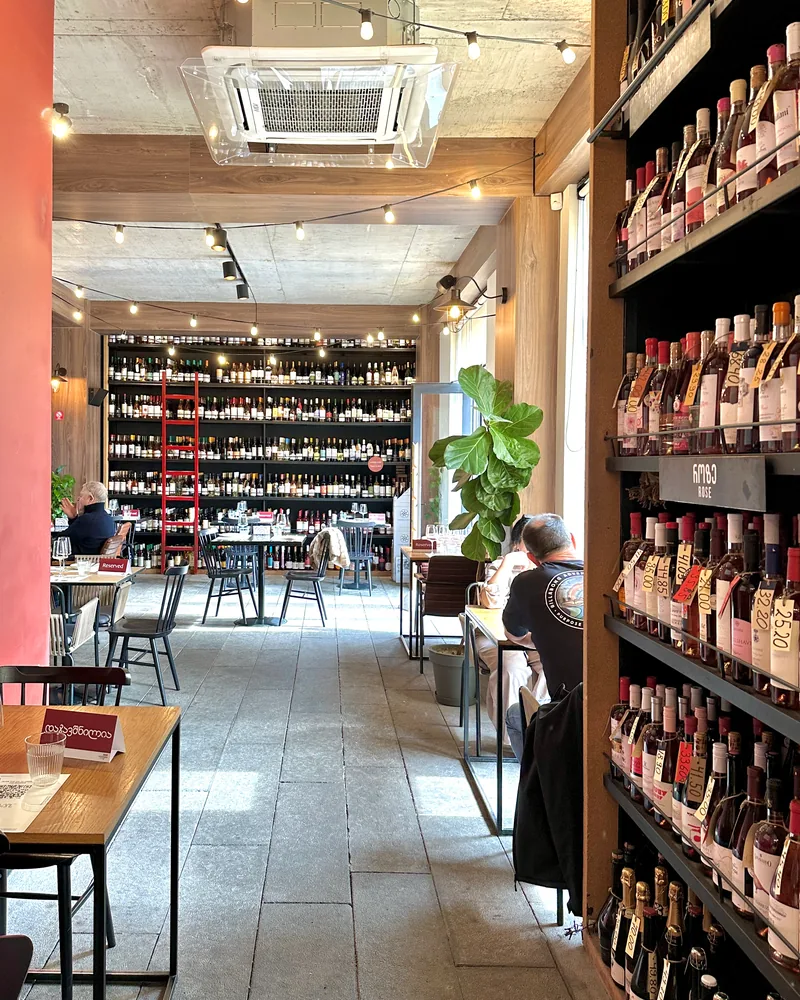Wine bar seating with floor-to-ceiling bottle racks at 8000 Vintages