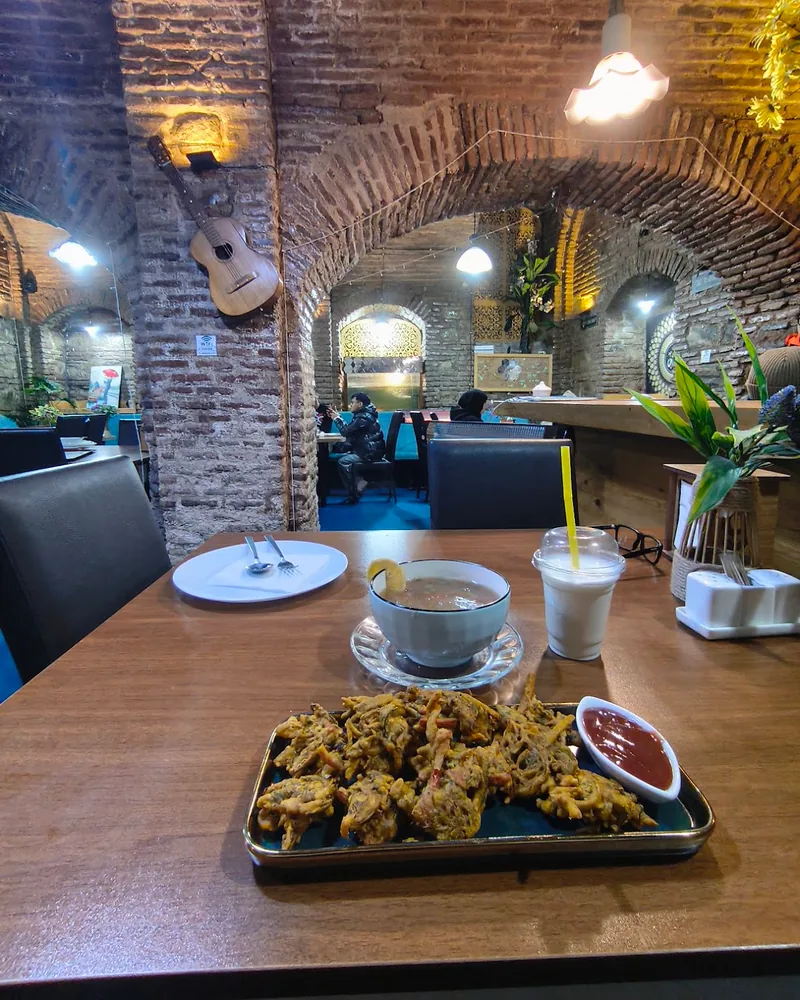 Fried vegetable pakoras with dipping sauce and soup at Al Madina Cave