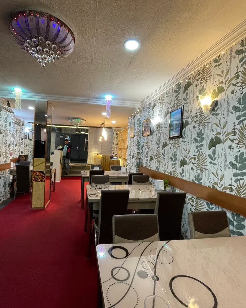 Dining room with red carpet and patterned wallpaper at Al Mecca