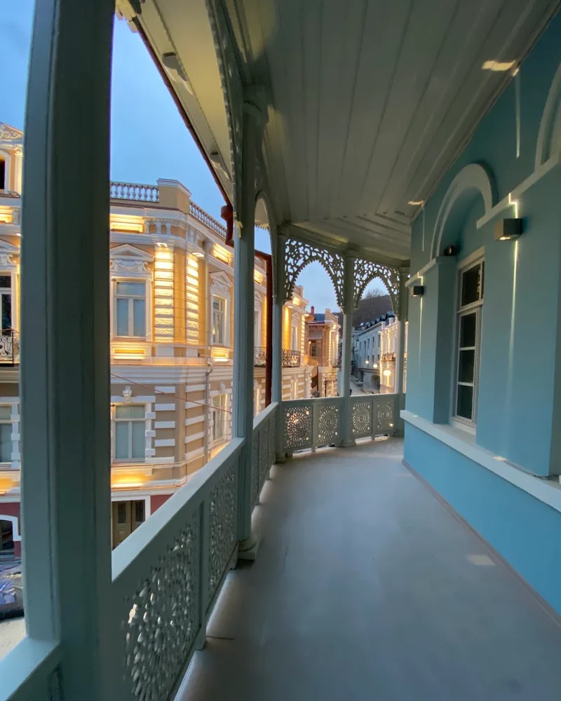 Traditional carved wooden balcony overlooking street at Ambavi
