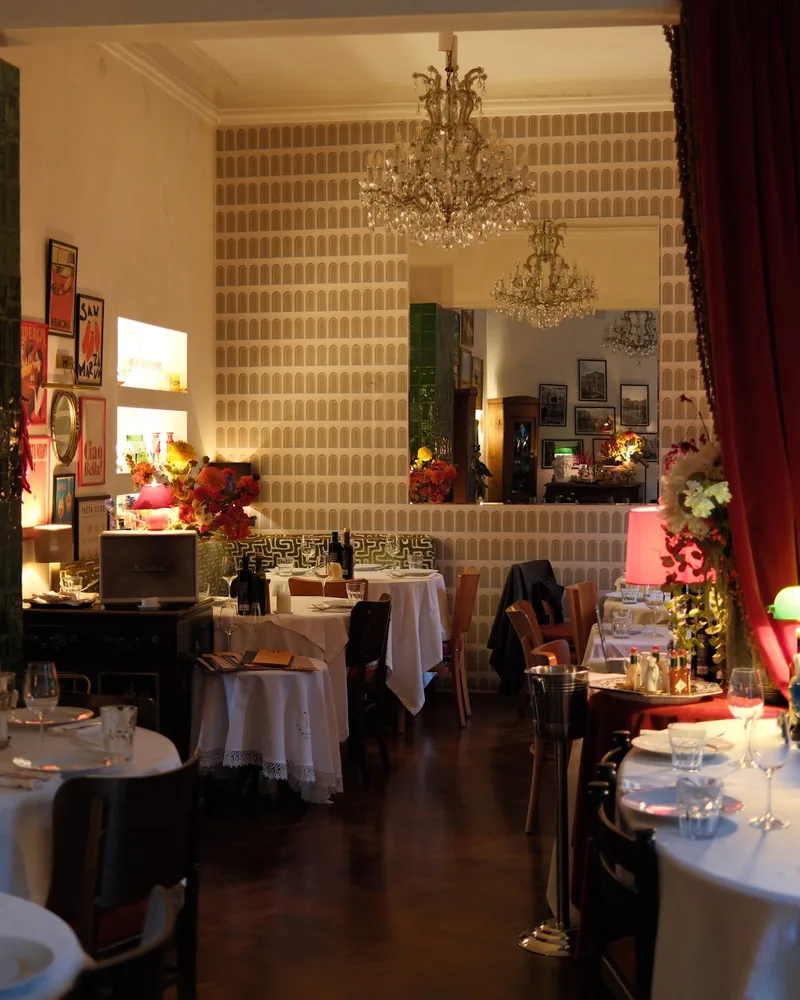 Dining room with chandelier and green tiled column at Ambrosiano