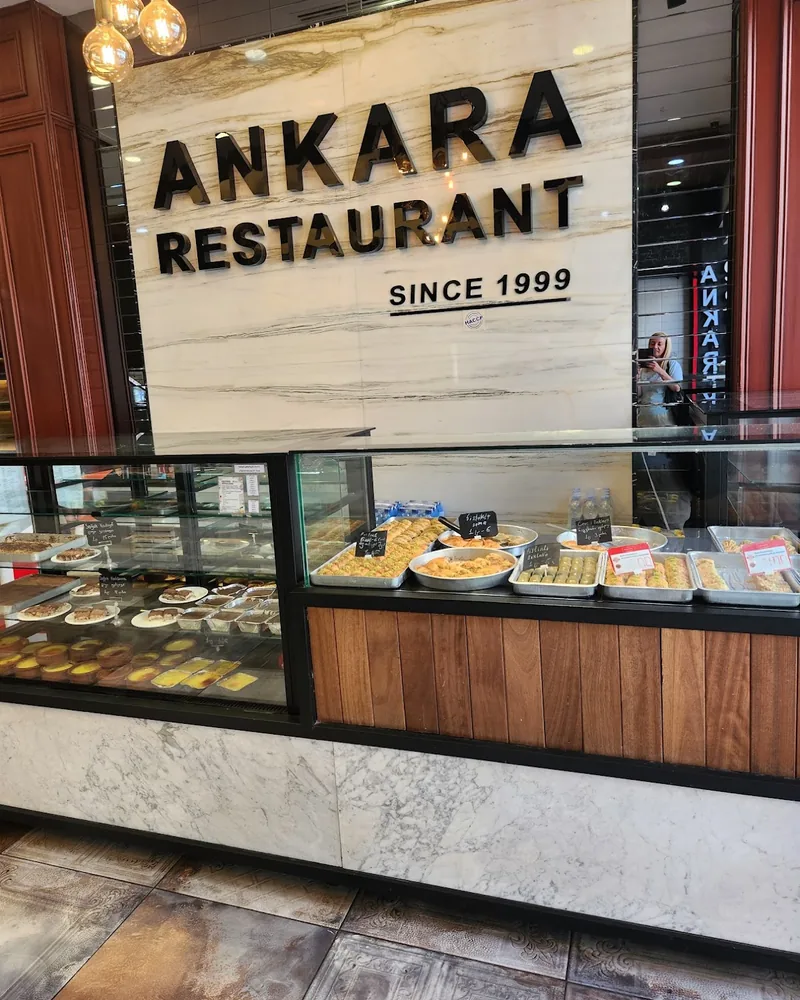 Dessert counter with baklava and restaurant sign at Ankara Style