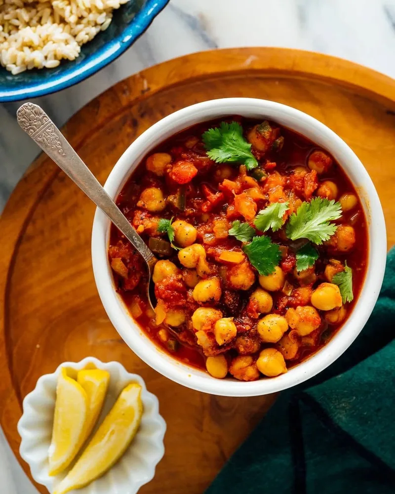 Chana masala in a white bowl garnished with coriander at Aroma