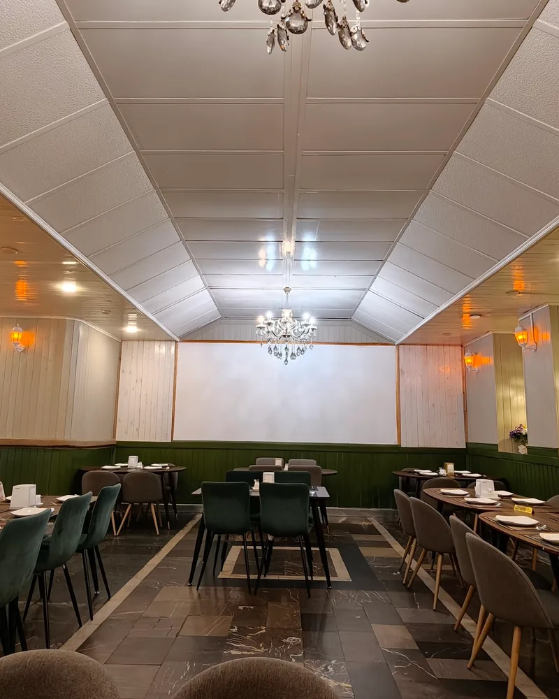 Dining room with wood panelling and green banquettes at Aroma