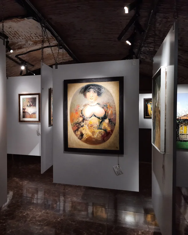 Art gallery area with framed paintings on partitions at Art Hub & Wine Bar