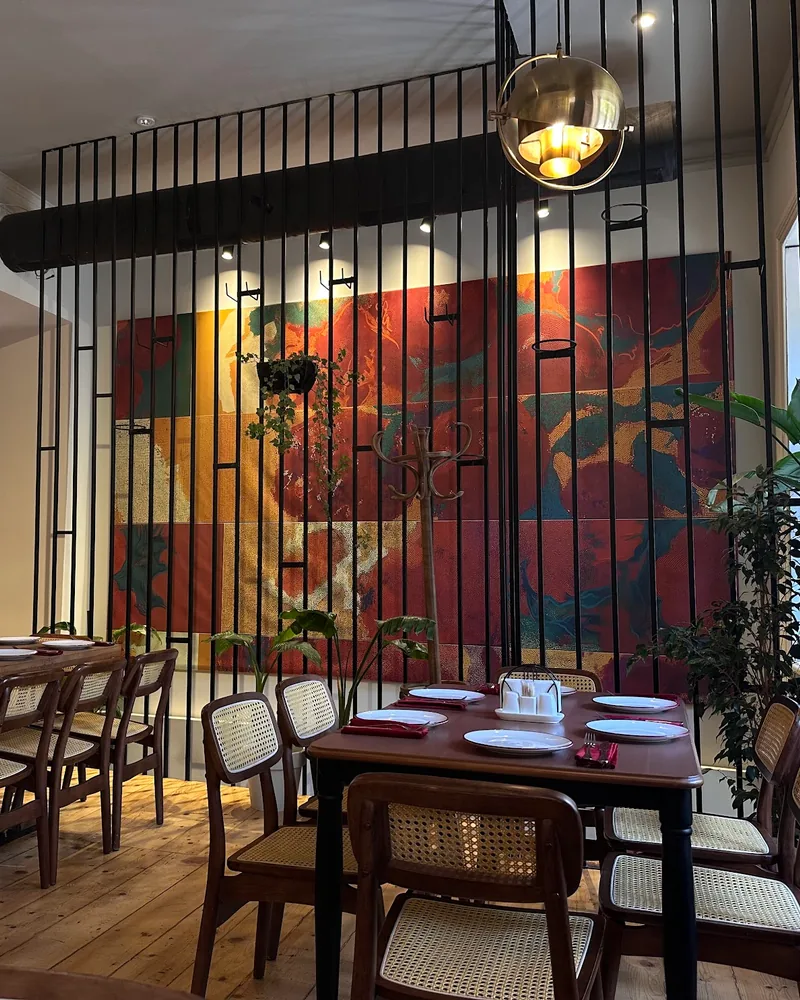 Dining room with wooden tables and cane chairs at Asi Khinkali