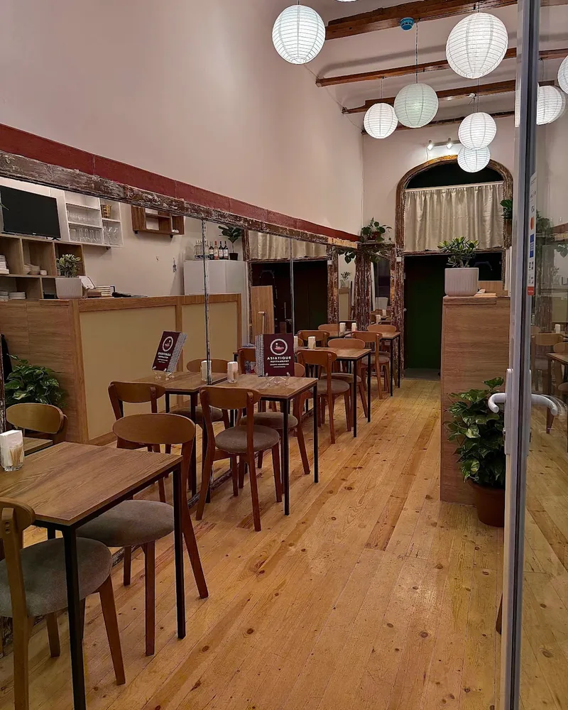 Dining room with wooden tables and paper globe lanterns at Asiatique House & Bubble Tea