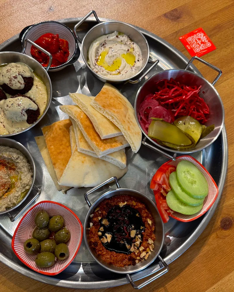 Mezze platter with pita, dips, falafel and pickles at Aut Vera