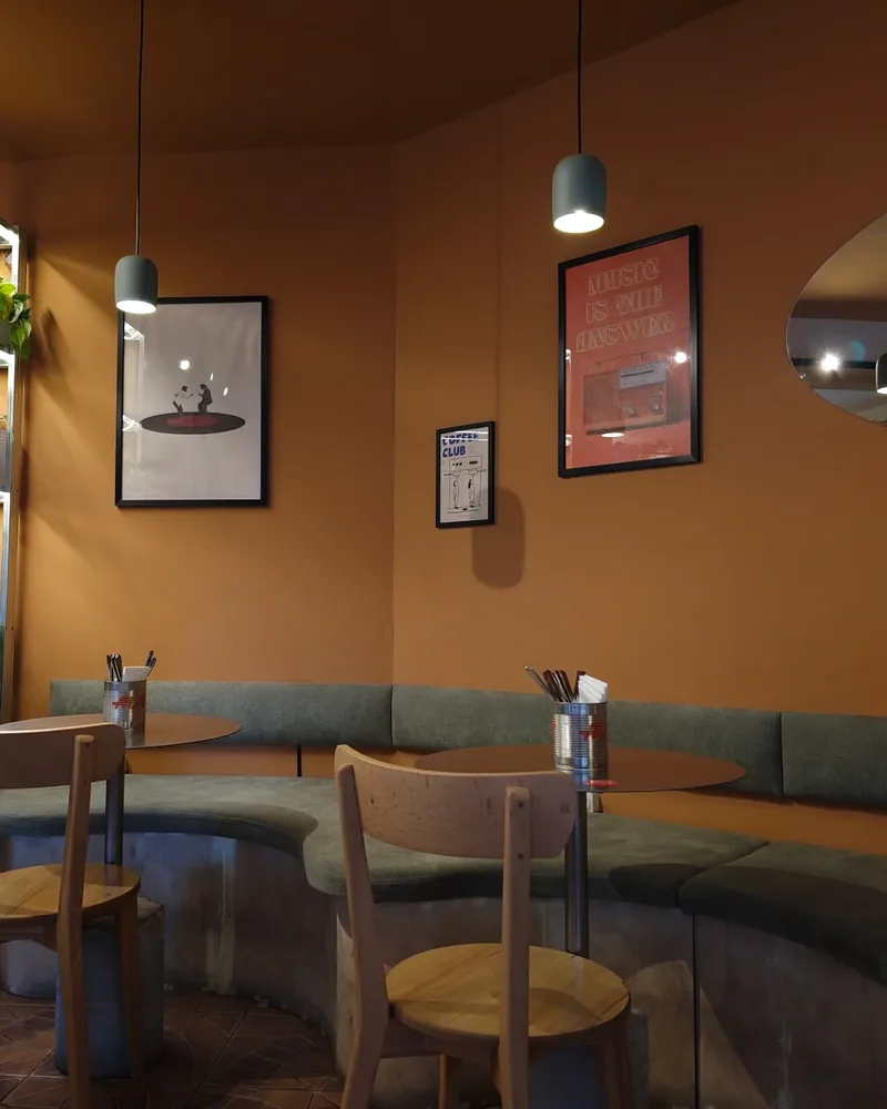 Terracotta dining corner with curved banquette and wooden chairs at Aut Vera