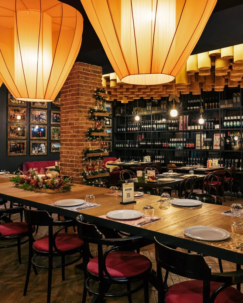 Dining room with large paper lantern lights and wine racks at Badagoni