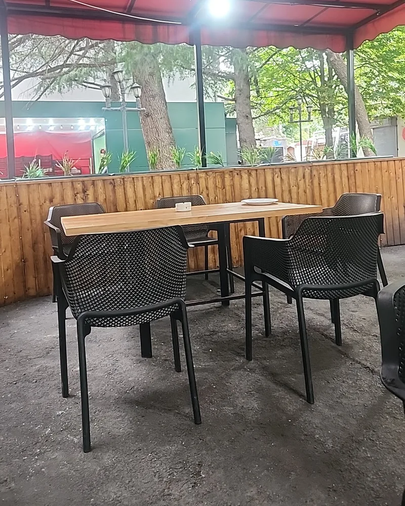 Covered outdoor dining area with red awning at Balu BBQ shaurma
