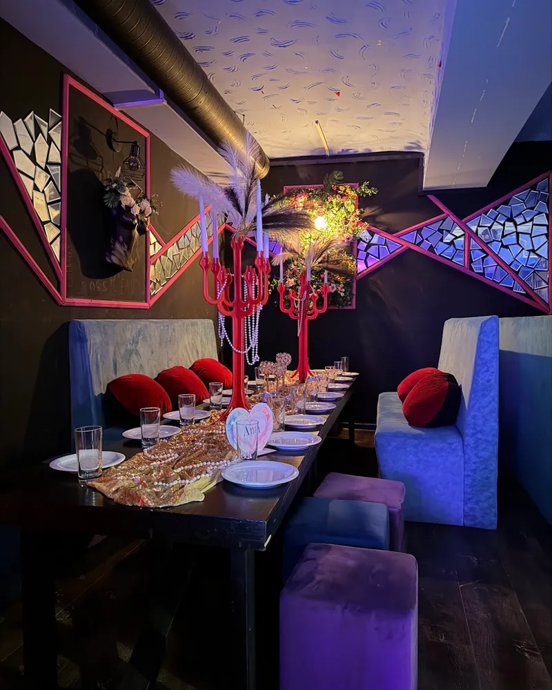Private dining table with red candelabra and velvet booths at Bar 28