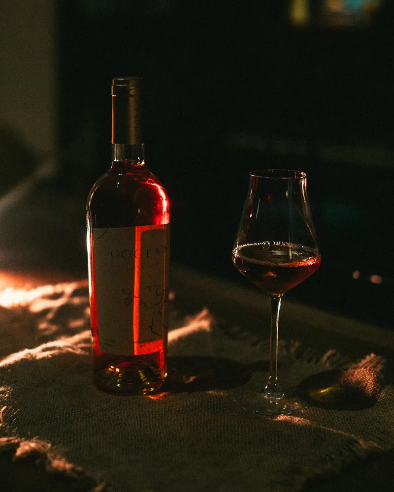Bottle and glass of rosé wine on a burlap cloth at Bar Happens