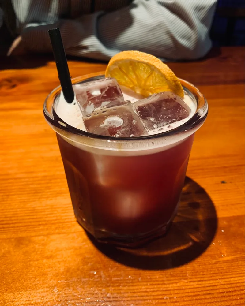 Cocktail with ice and dried orange slice at Bar 36