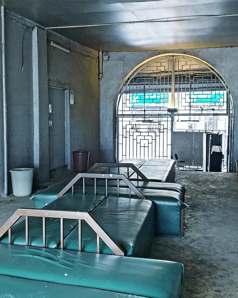 Concrete hallway with green vinyl benches at Bassiani