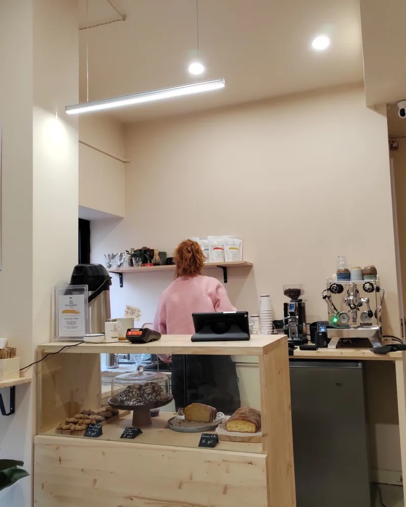 Wooden counter with pastry display and espresso machine at Beanbourbon Roasters
