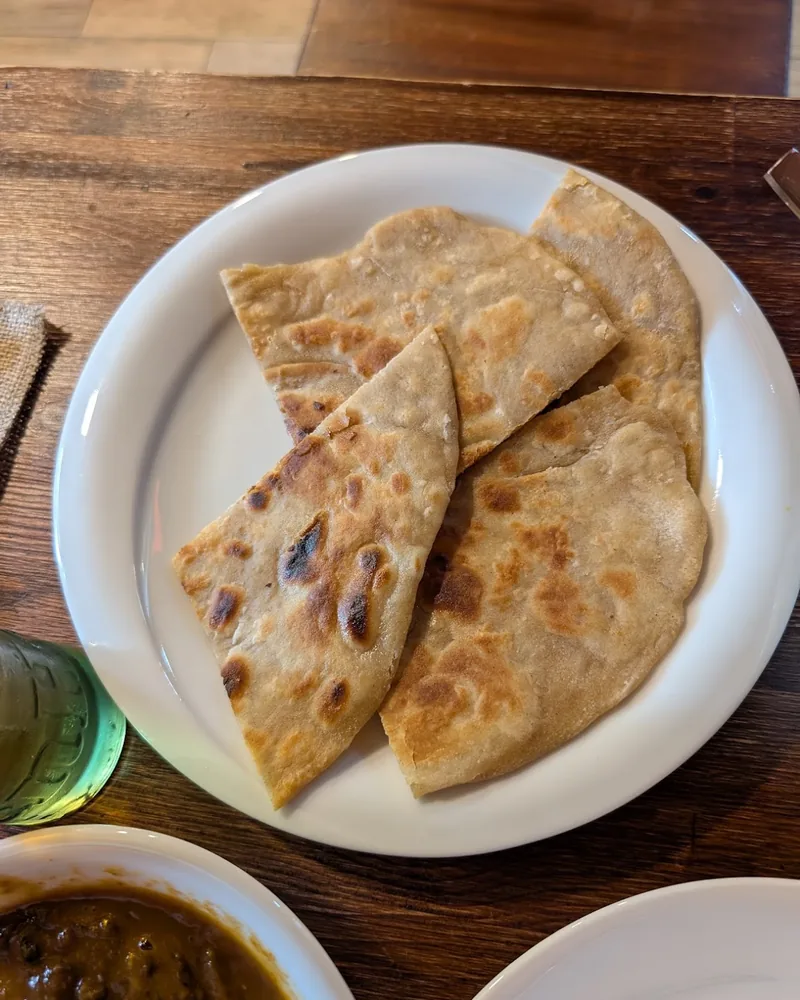 Roti flatbread slices on a white plate at Beans & Barrel