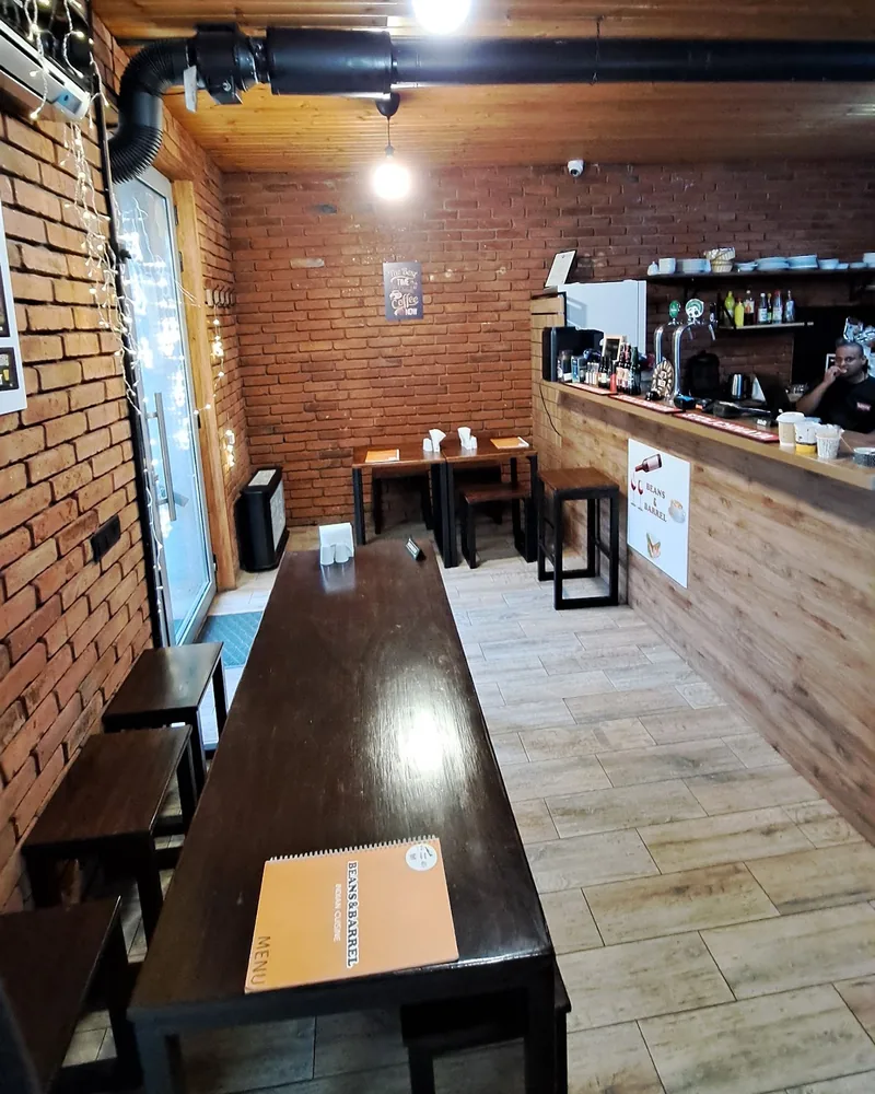 Dining room with a wooden ceiling and brick walls at Beans & Barrel