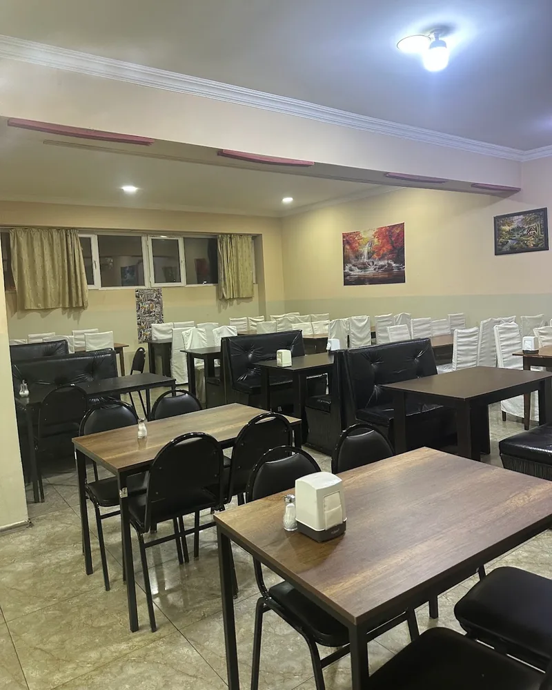 Dining room with wooden tables and black chairs at Beirut
