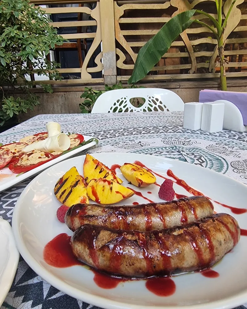 Grilled sausages with sauce and peaches at Beletage Restaurant