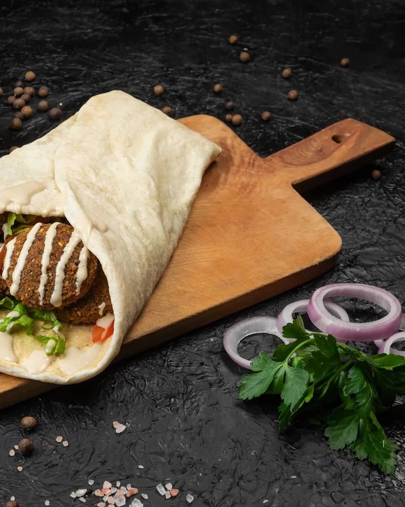 Falafel wrap on a wooden serving board at Best Pizza in Tbilisi