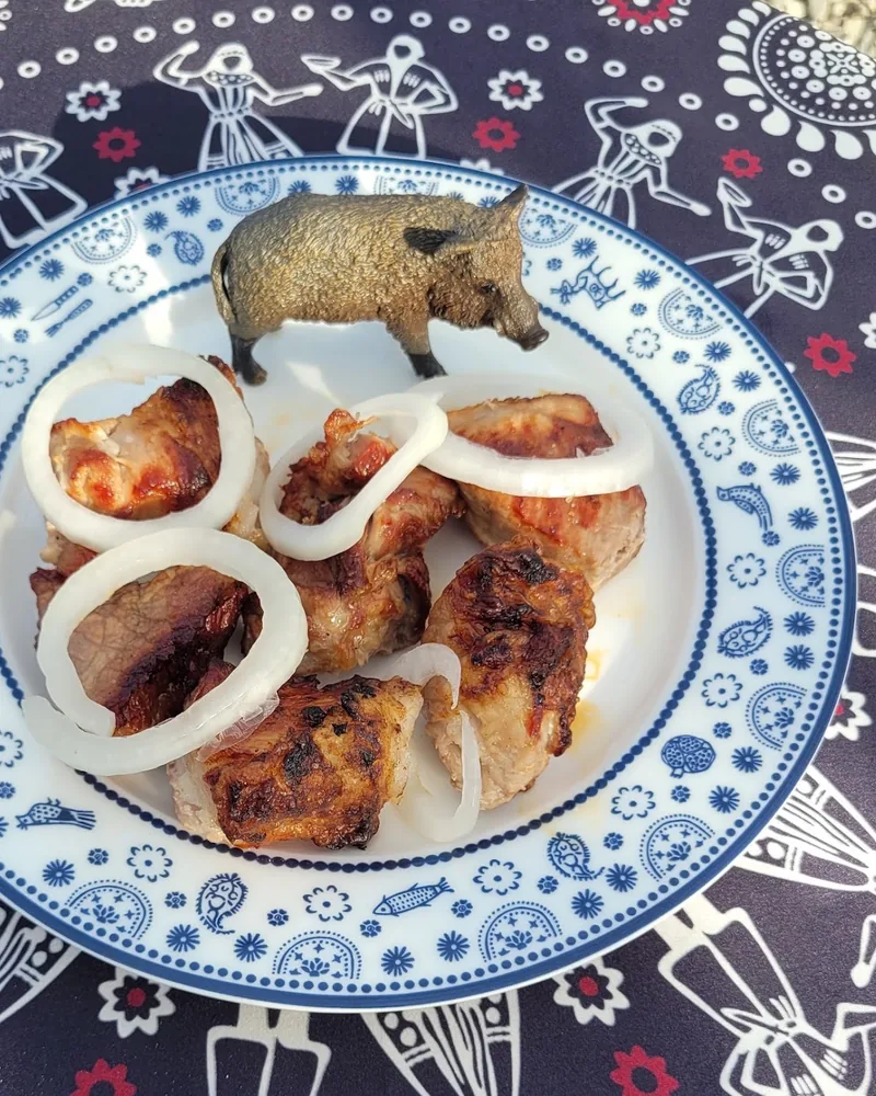 Mtsvadi with raw onion rings and boar figurine at Big Boar