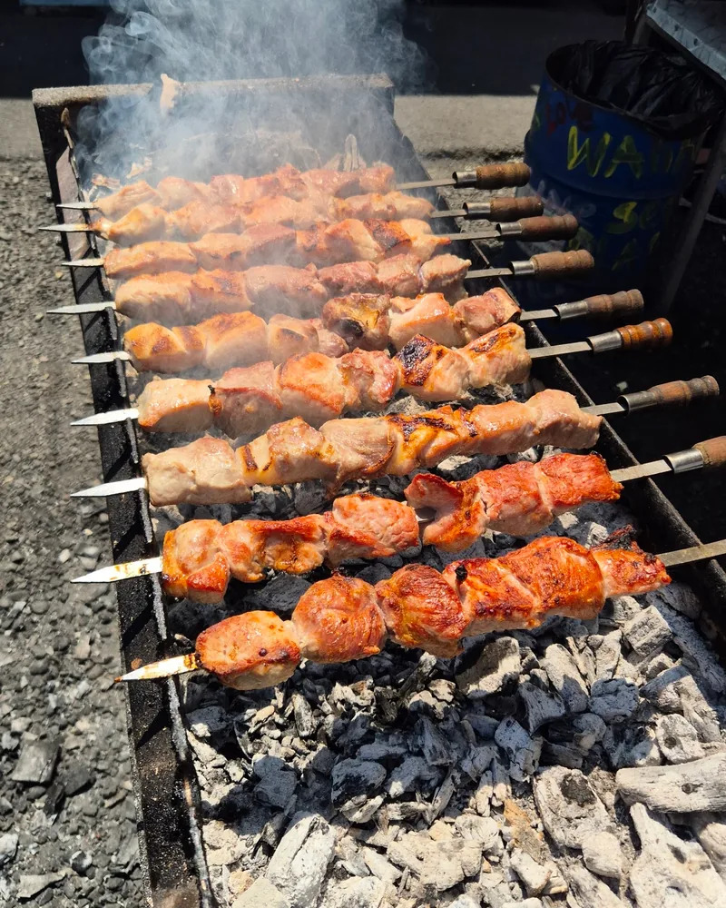 Mtsvadi skewers grilling over hot coals at Big Boar