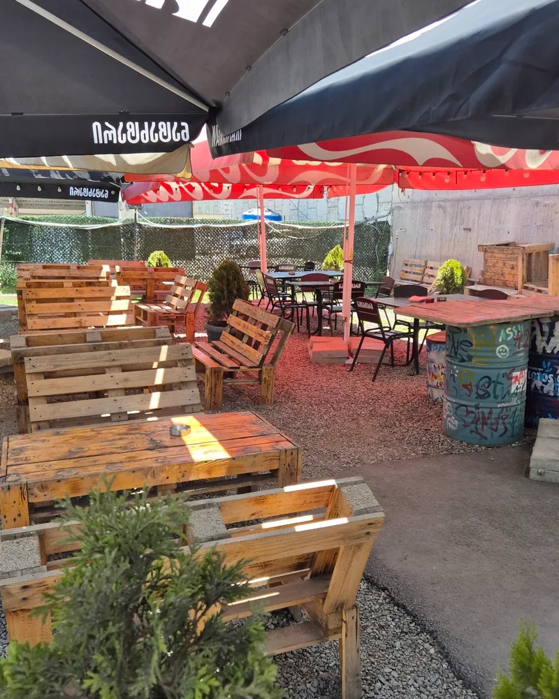Outdoor patio with pallet furniture and umbrellas at Big Boar