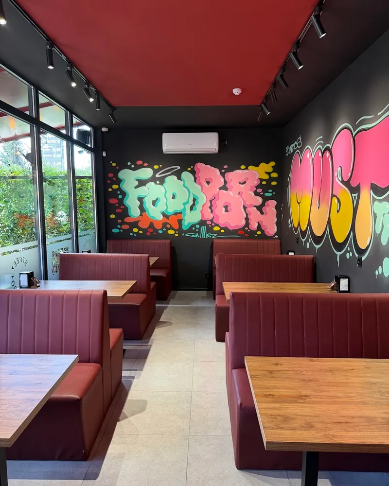 Dining area with red booths and graffiti wall art at Big Sam's
