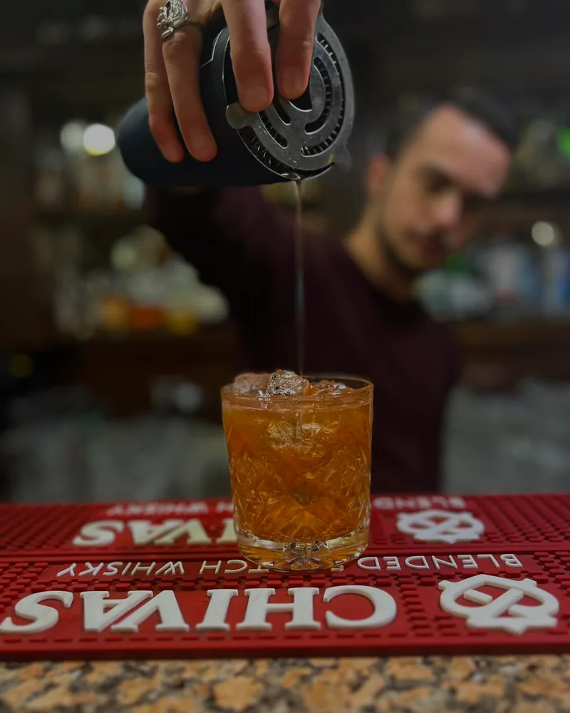 Whiskey cocktail being poured into a rocks glass at Billy Burke’s Irish Pub