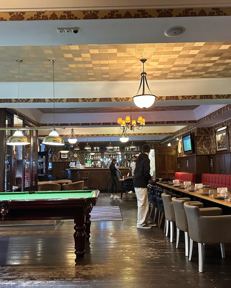 Pub dining room with pool table and long table at Billy Burke’s Irish Pub