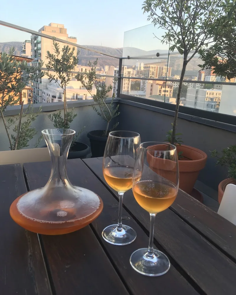 Decanter and glasses of amber wine on a rooftop table at Bina N37