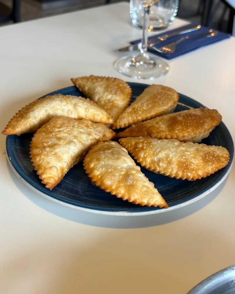 Fried dumplings on a blue plate at Bistro Conili
