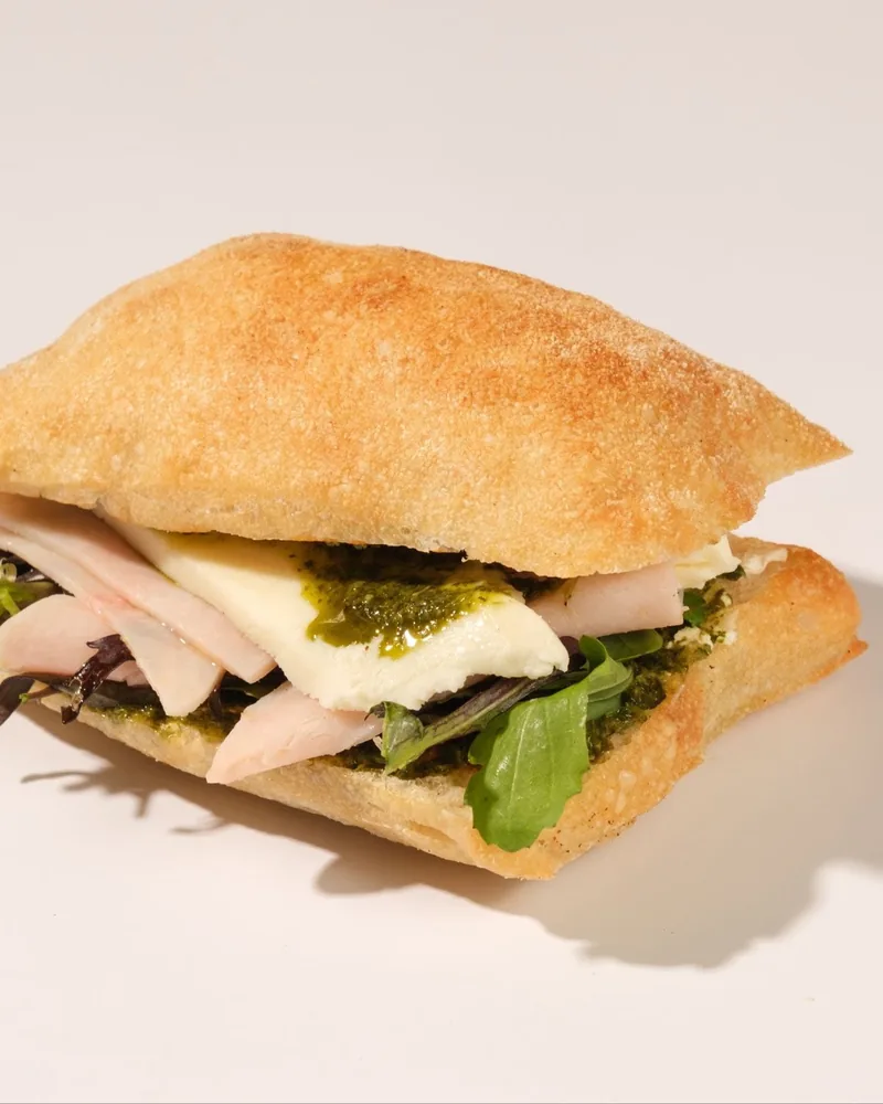 Ciabatta sandwich with mozzarella, sliced meat, and pesto at Brod the Bakery