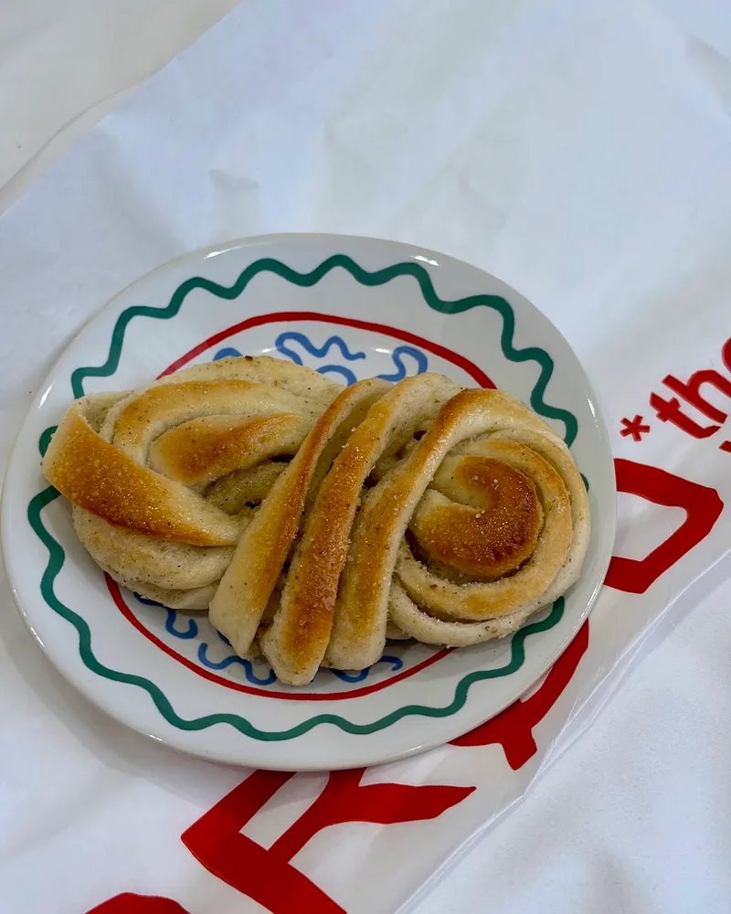 Cardamom bun on a patterned plate at Brod the Bakery