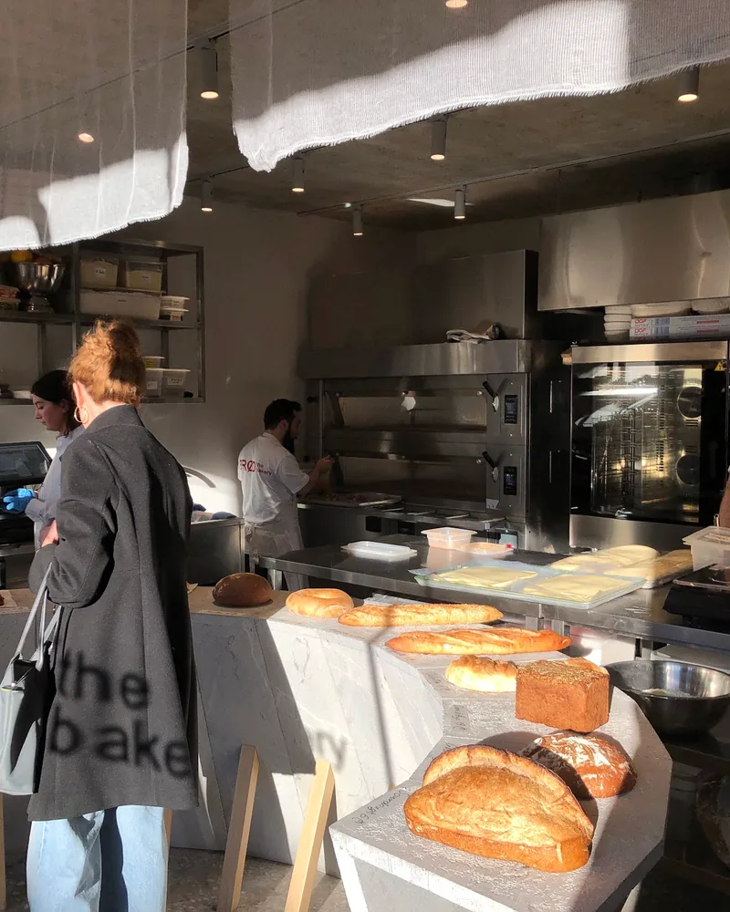 Bakery counter with artisan bread and open kitchen at Brod the Bakery