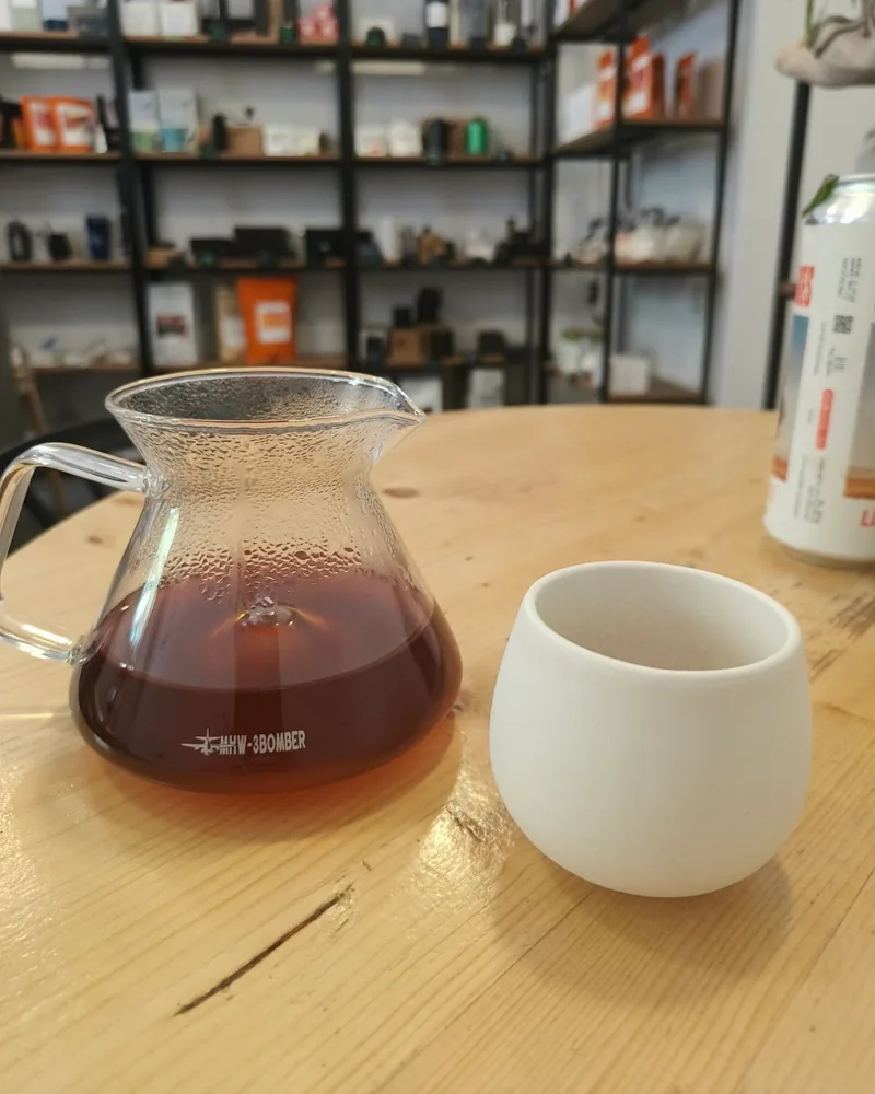 Filter coffee in a glass server next to a white ceramic cup at Brewio