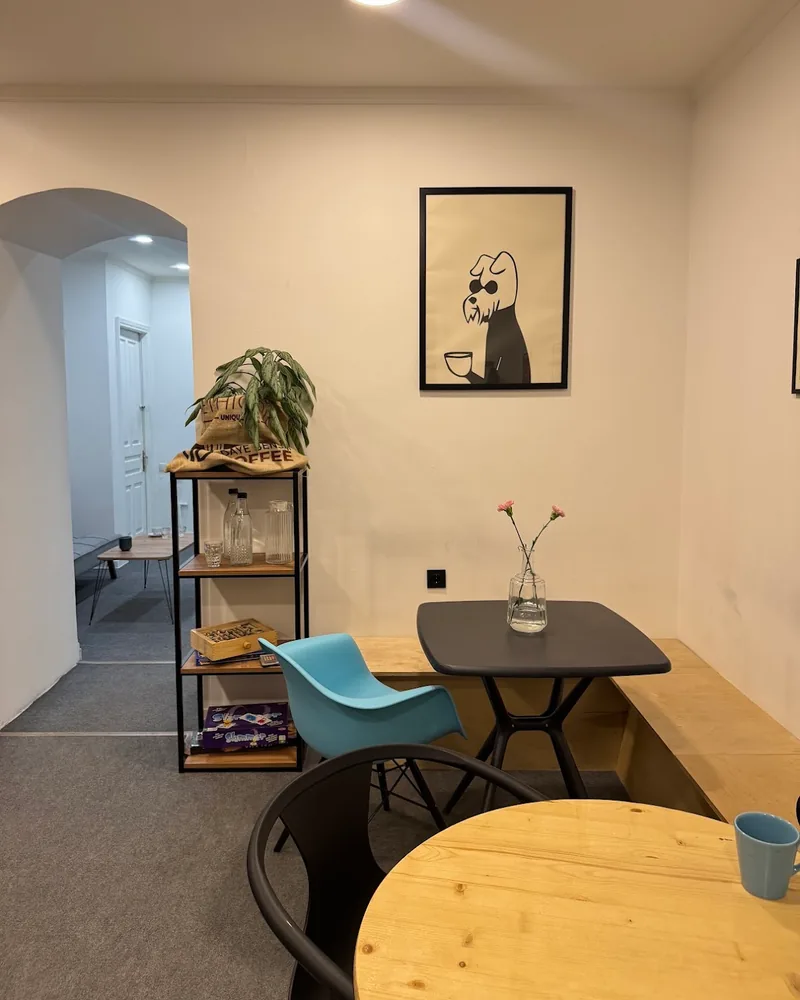 Cafe seating corner with small tables and poster art at Brewio