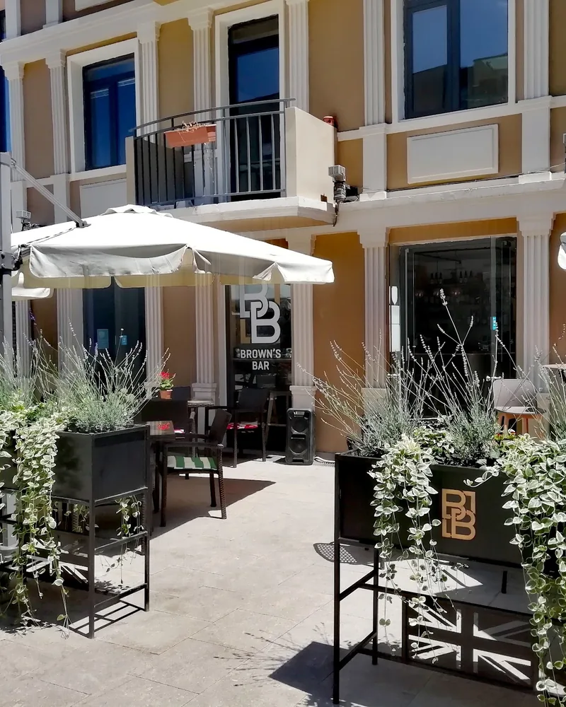 Outdoor terrace seating with planters and umbrellas at Brown's Bar