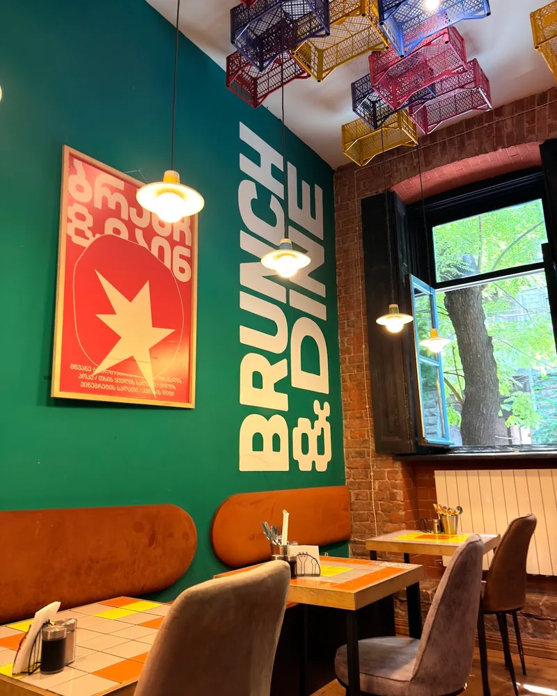 Cafe dining area with green accent wall and crate ceiling at Brunch & Dine