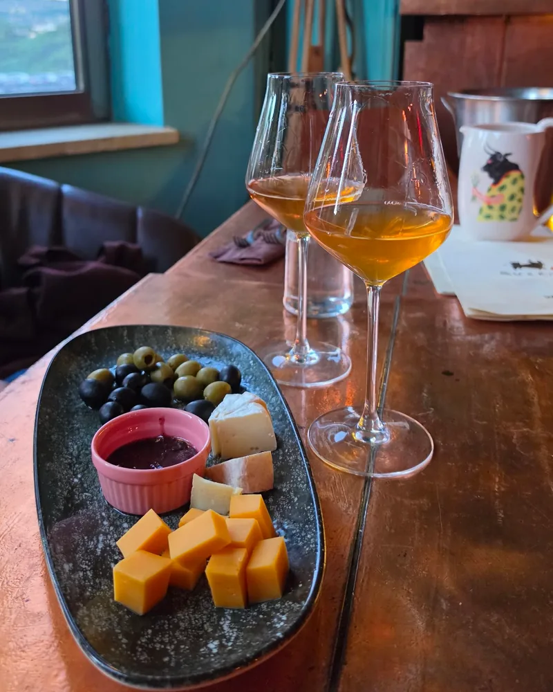 Amber wine in glasses with cheese and olive platter at Bu & Khari