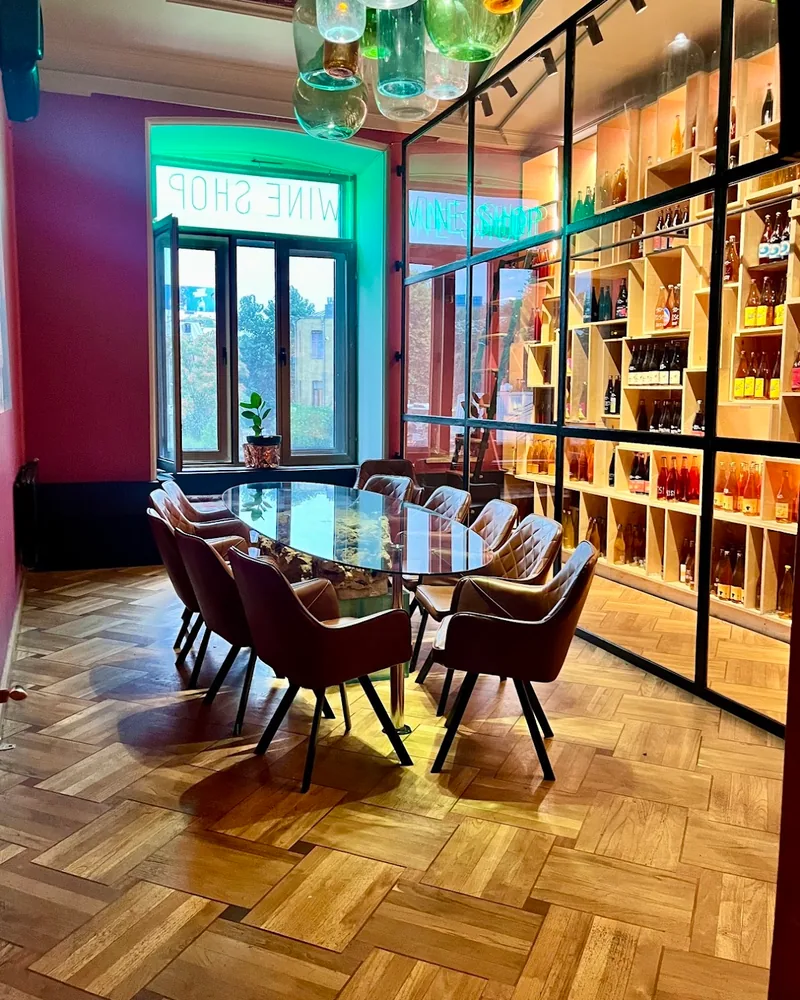 Wine tasting room with glass wall display and oval table at Bu & Khari